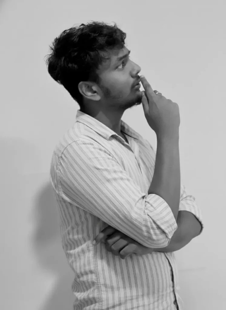 Side profile of a Best Digital Marketing Specialist In Alappuzha thoughtfully looking upward with hand on chin against a plain background.